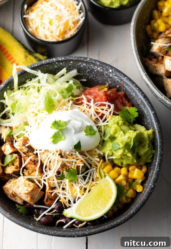 Homemade Chipotle Meal Prep Bowls 2 Close-up view of a homemade chicken chipotle burrito bowl, showing grilled chicken, rice, black beans, corn, and fresh toppings.