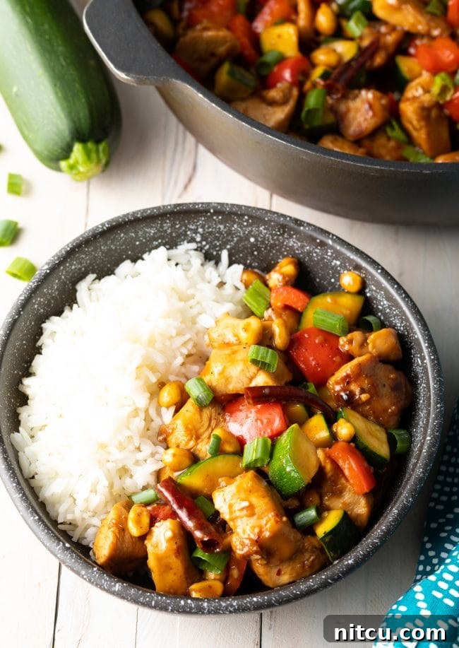 Sichuan Kung Pao Chicken 11 Authentic kung pao chicken with steamed white rice in a black bowl.