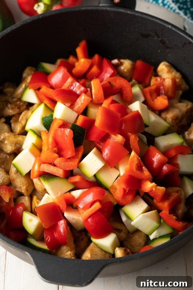 Sichuan Kung Pao Chicken 9 Cast iron skippet with chopped zucchini and red bell peppers.