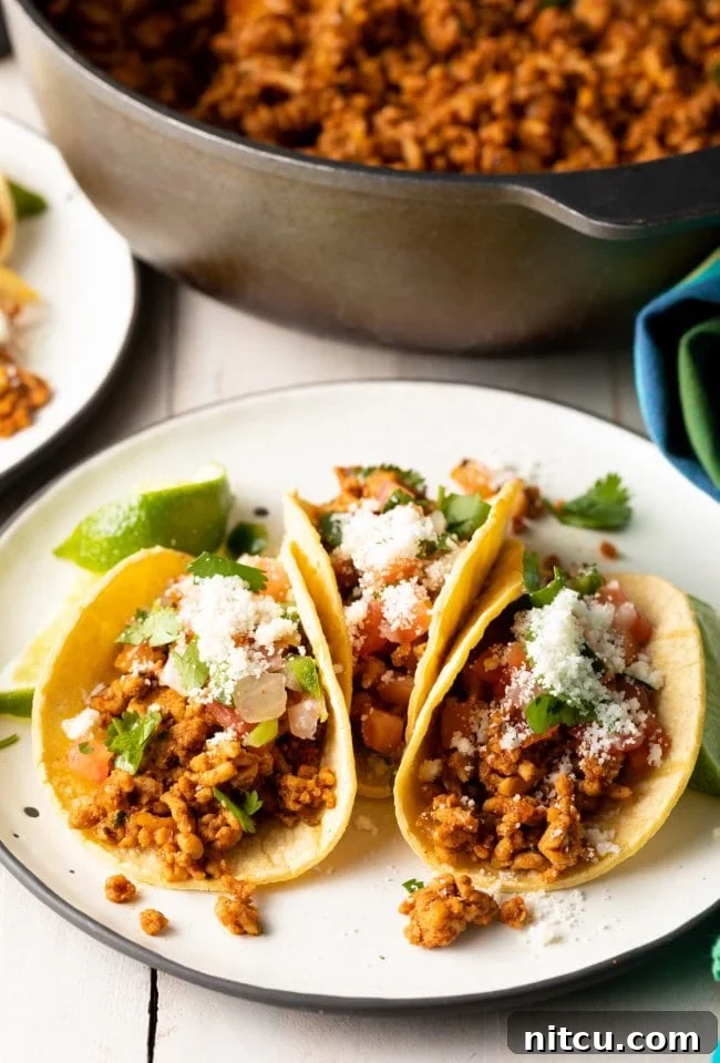 Dynamite Turkey Tacos 2 Spicy ground turkey tacos on a plate with a skillet in the background