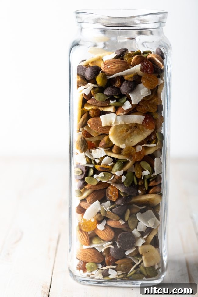 Wholesome DIY Trail Mix 6 A side view of a stylish glass jar filled with healthy trail mix, showcasing its layers.