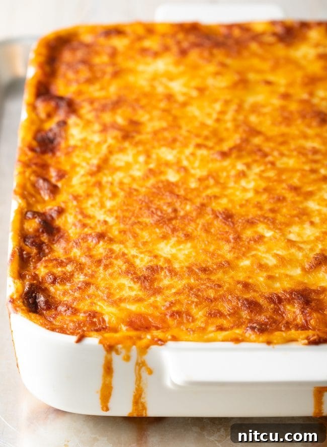 Hearty Greek Pastitsio Casserole 12 Close view of cheesy pasitsio in a white baking dish.