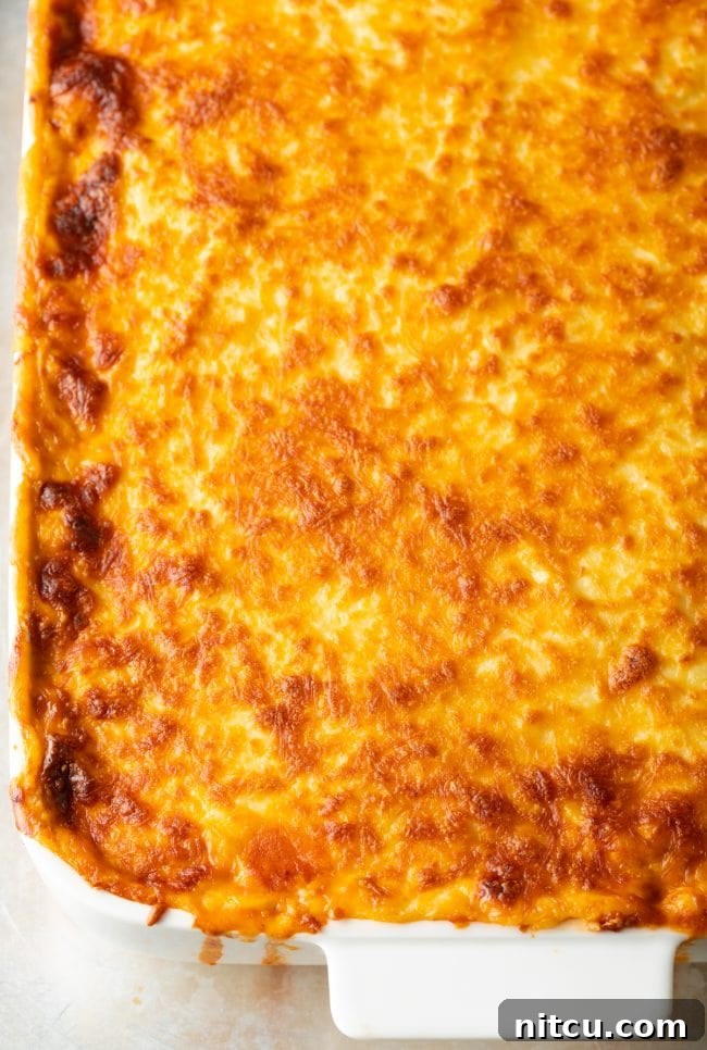 Hearty Greek Pastitsio Casserole 13 Top down view of cheesy pasitsio in a white baking dish.