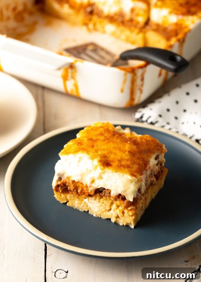 Hearty Greek Pastitsio Casserole 14 Square of homemade pastitsio on a gray plate.