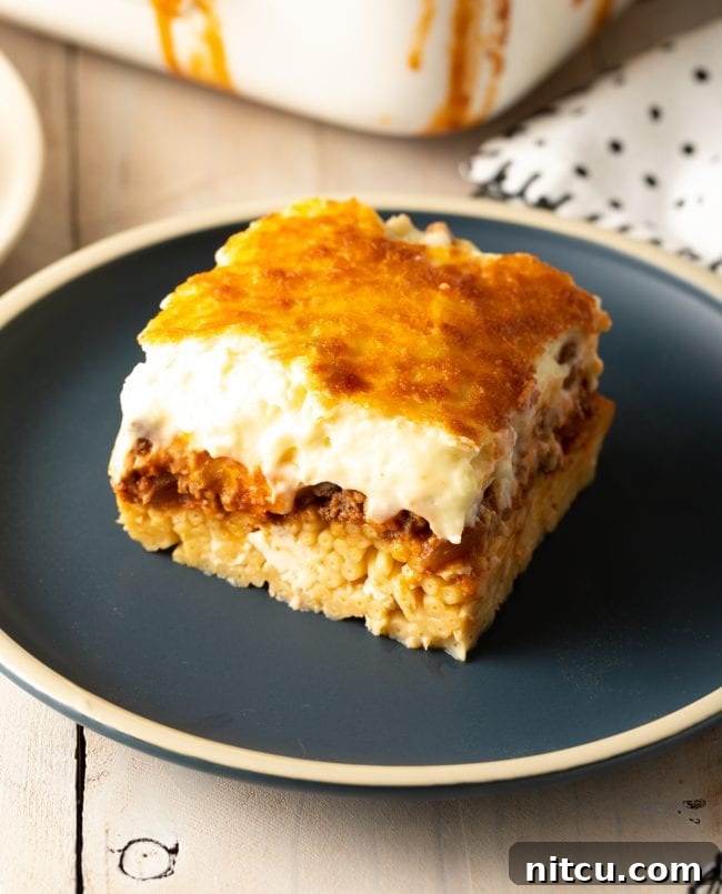 Hearty Greek Pastitsio Casserole 15 Square of homemade pastitsio on a gray plate.