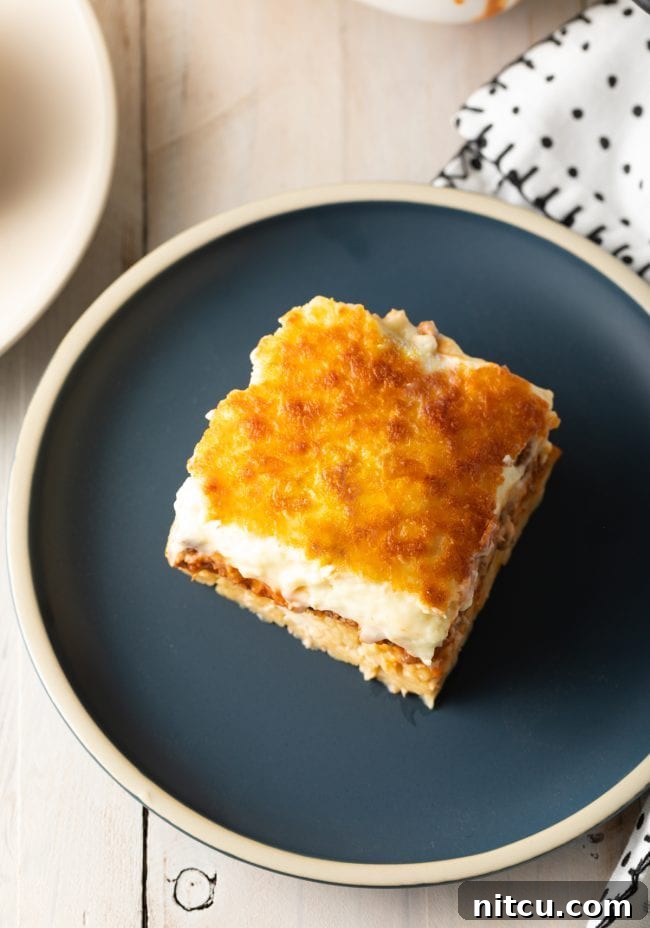 Hearty Greek Pastitsio Casserole 3 Top down view square of pastitsio on a gray plate.