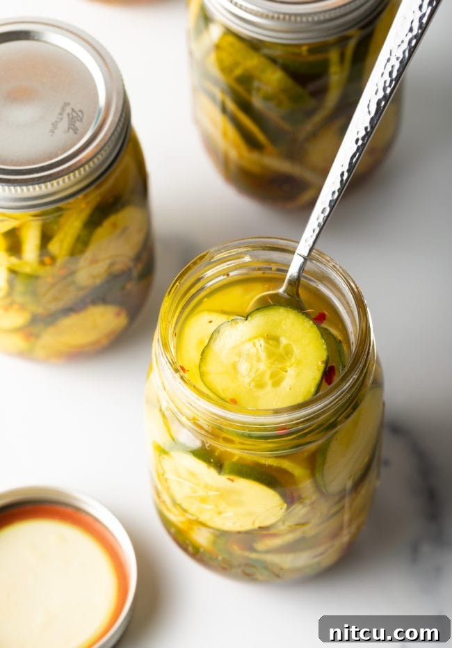 Effortless Homemade Bread & Butter Pickles 12 Overhead view of an opened jar of bread and butter sweet pickles with a fork.