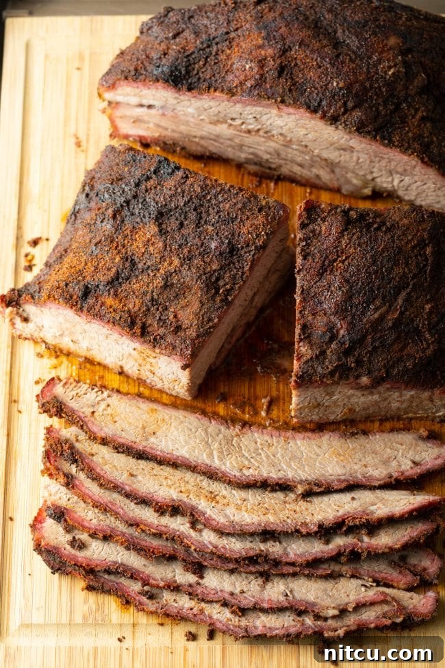 Ultimate Dry-Brined Smoked Brisket 12 A sharp knife slicing through perfectly rested beef brisket on a cutting board, revealing the tender interior.