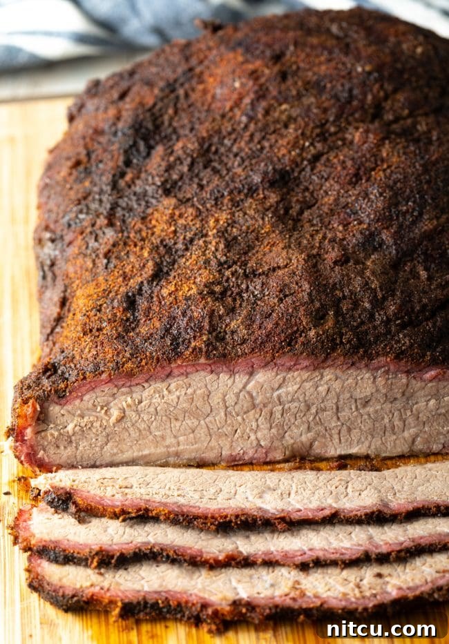 Ultimate Dry-Brined Smoked Brisket 14 Overhead view of perfectly sliced beef brisket on a cutting board, ready to serve.