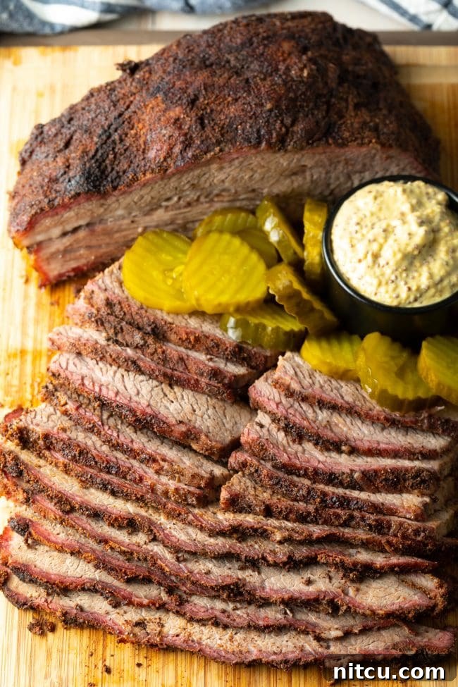 Ultimate Dry-Brined Smoked Brisket 15 Smoked brisket sliced to perfection, served with pickles and mustard on a wooden board.