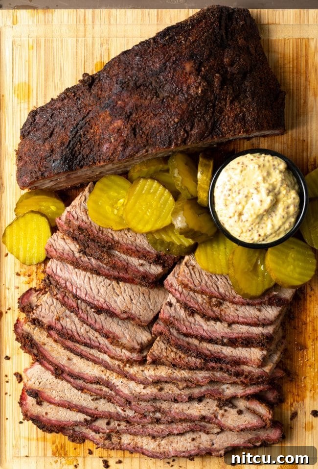 Ultimate Dry-Brined Smoked Brisket 5 Dry Brine Brisket - slices of smoked beef brisket on a board with pickles and mustard
