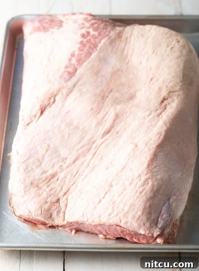 Ultimate Dry-Brined Smoked Brisket 7 Trimmed beef brisket resting on a baking sheet, ready for the dry brine.