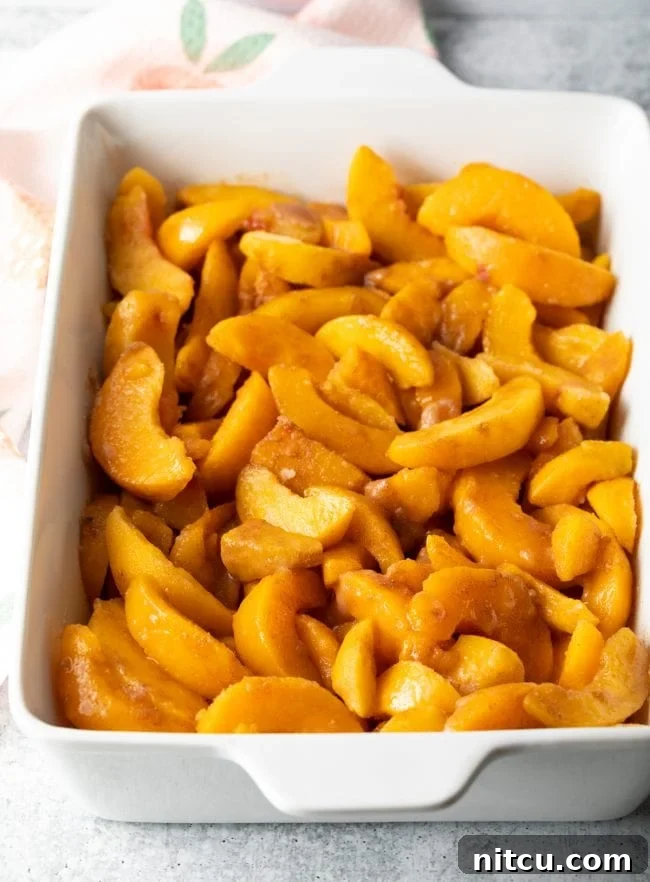 Easy Bisquick Peach Cobbler 4 sliced peaches in a baking dish