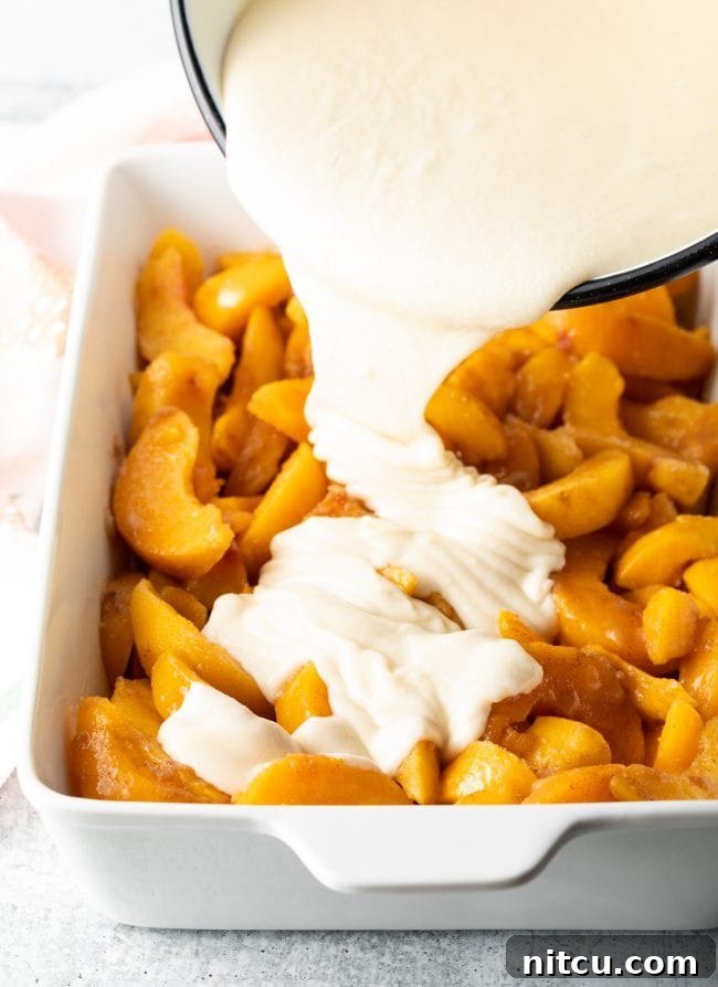 Easy Bisquick Peach Cobbler 7 pouring the batter over the fruit