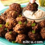 Bahamian conch fritters served with dipping sauce, garnished with fresh herbs.
