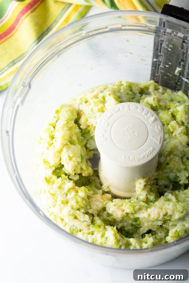 A close-up of the finely chopped conch and vegetable mixture in a bowl, ready to be combined with dry ingredients for the fried conch fritters recipe.