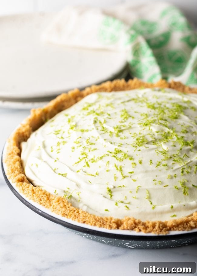 Effortless Key Lime Pie 11 A beautifully garnished key lime icebox pie, complete with a fresh dusting of lime zest, presented in its pie pan, ready to be sliced and served as a refreshing dessert.