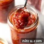 A beautifully crafted jar of homemade tomato jam, ready for serving.
