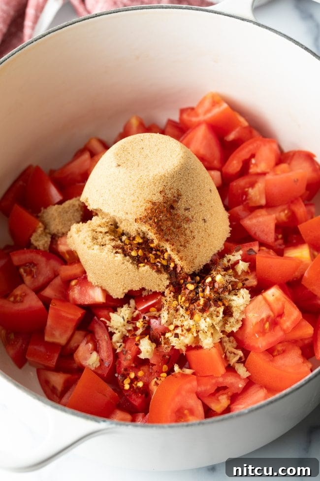 A mix of chopped tomatoes, rich brown sugar, and aromatic spices carefully combined in a pot, ready to simmer.