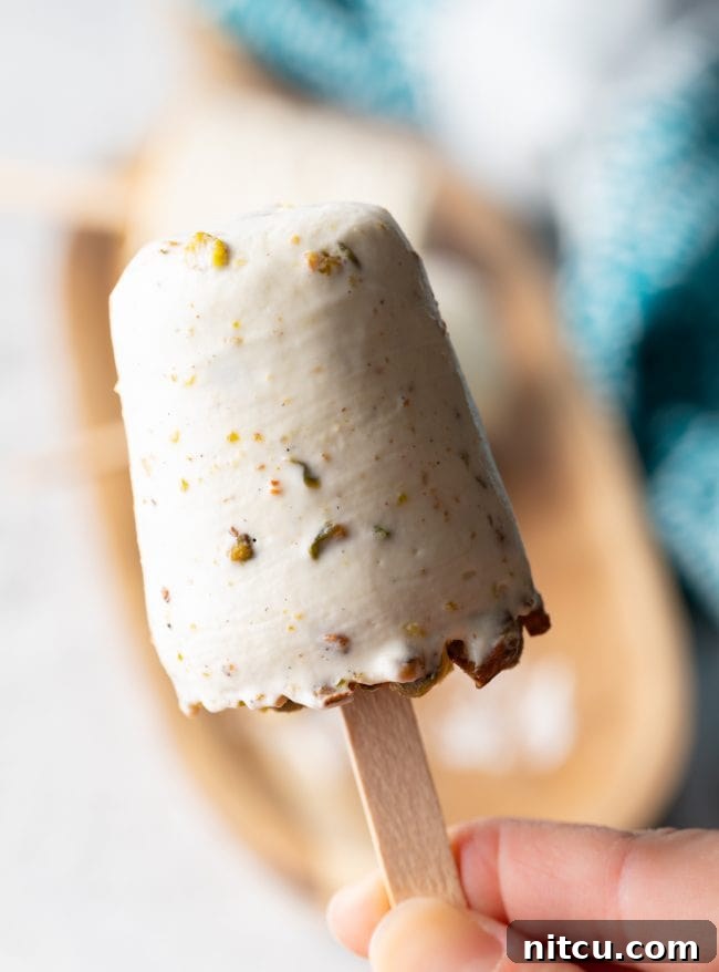 close up of pistachio ice cream pop on a wooden stick
