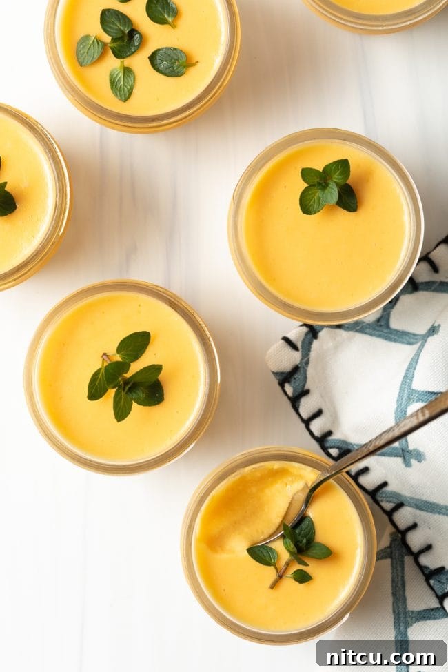 Creamy Vegan Mango Pudding 4 Overhead view of 4 dairy free Chinese mango pudding dessert pudding cups with mint leaves.