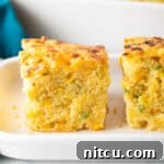 Jalapeno Cornbread recipe close up on plate, showing its golden crust and delicious toppings.