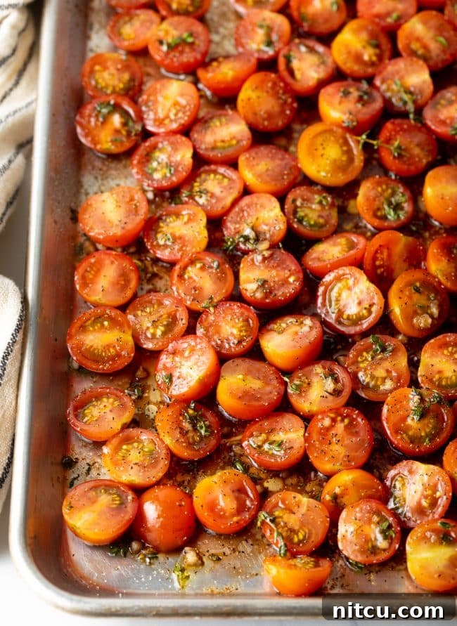 Oven-Kissed Cherry Tomatoes 7 Seasoned cherry tomatoes spread evenly on a baking pan, ready for roasting.