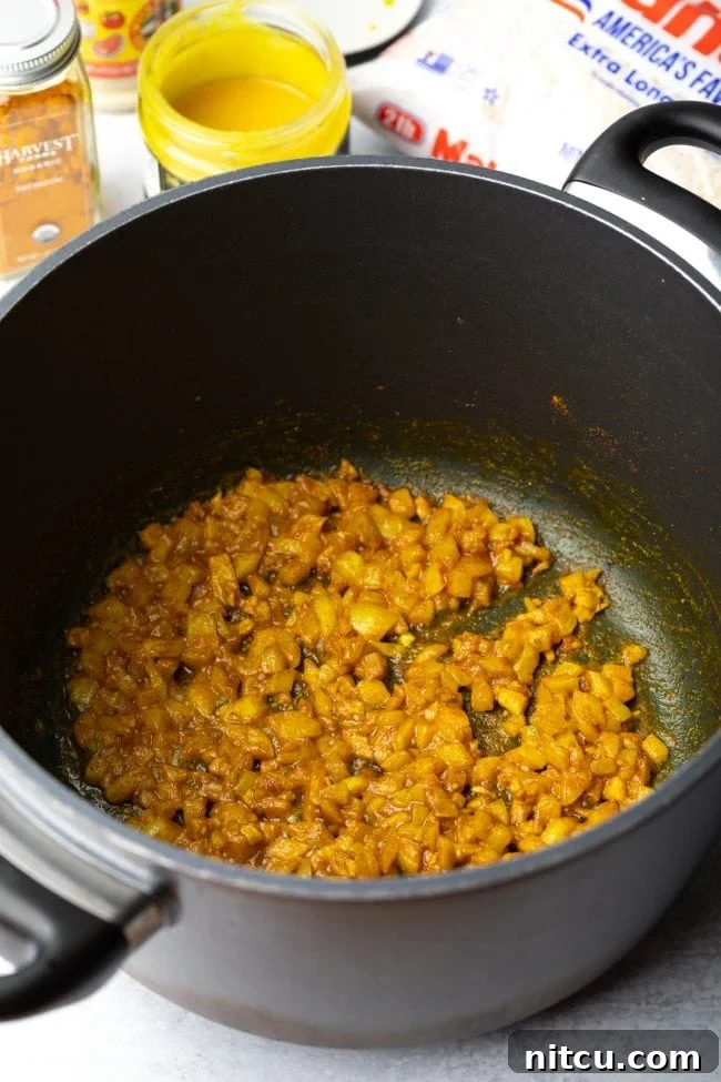Onions and garlic being sautéed in a cooking pan, releasing their aromatic flavors.