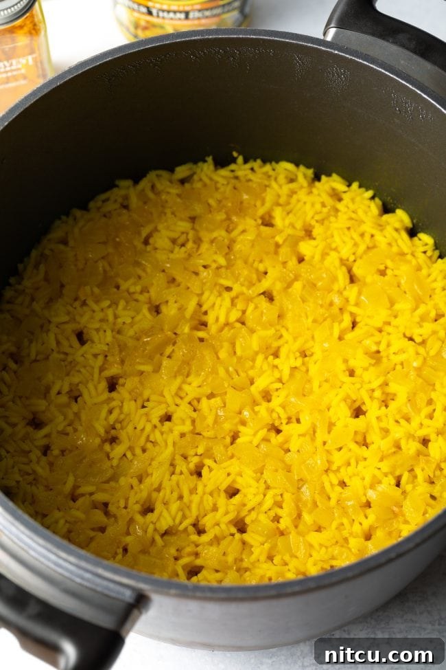 Perfectly cooked yellow rice in a pot, showing its fluffy texture and vibrant color.