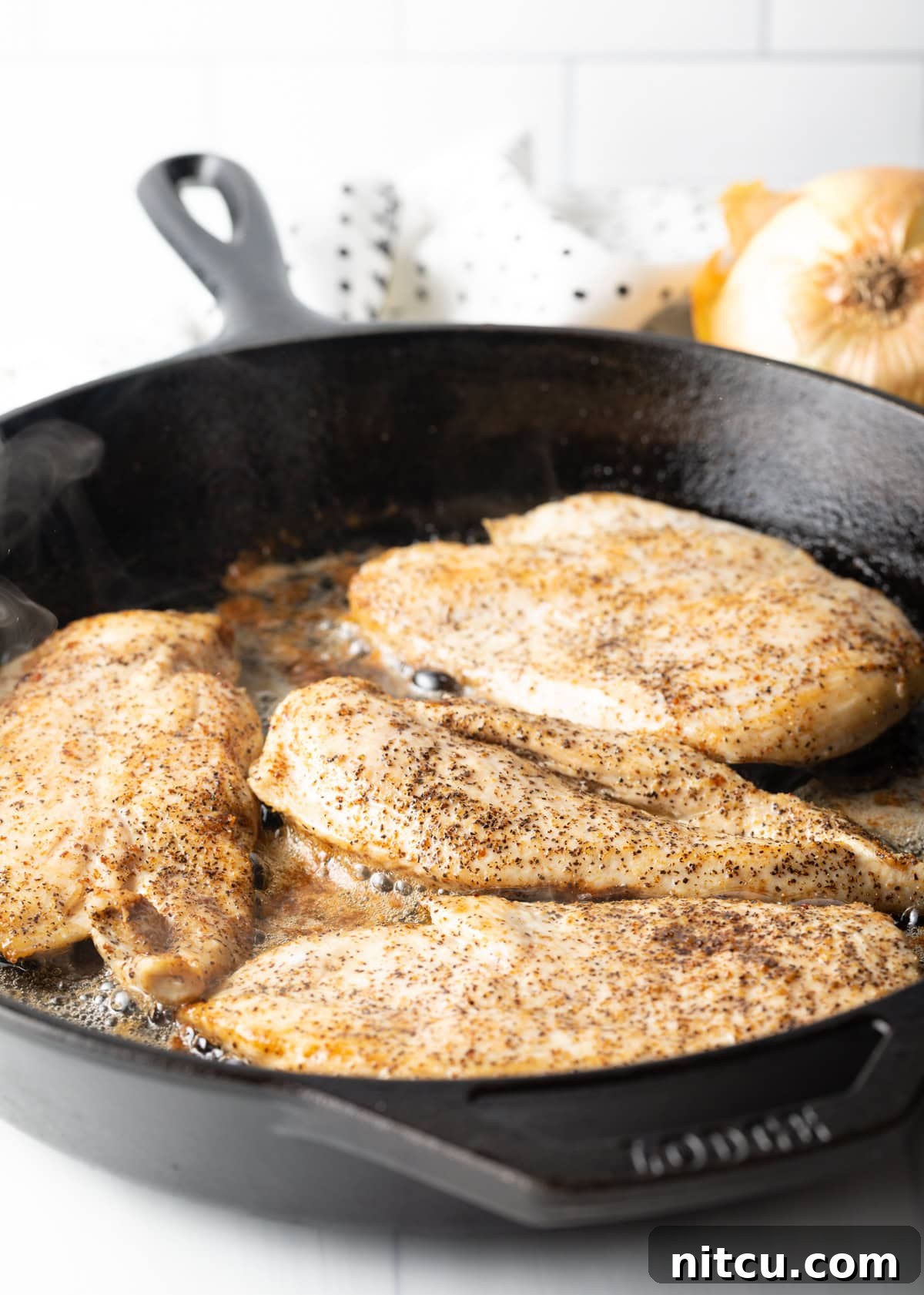 Braised Chicken Delight 6 Seasoned chicken breasts cooking to a golden brown in a cast iron skillet with hot bacon grease.
