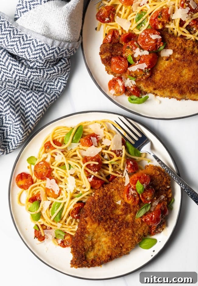 Crispy Italian Chicken Cutlets 3 overhead view two plates of pasta with fried chicken breasts and cherry tomato sauce