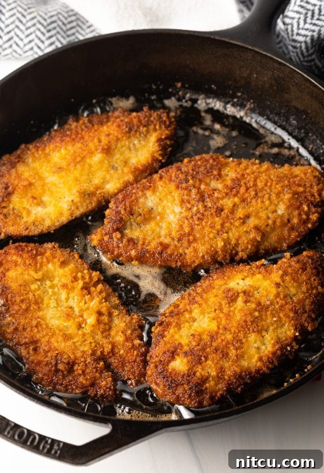 Crispy Italian Chicken Cutlets 7 large cast iron pan frying crispy chicken cutlets with Italian marinade and seasoning