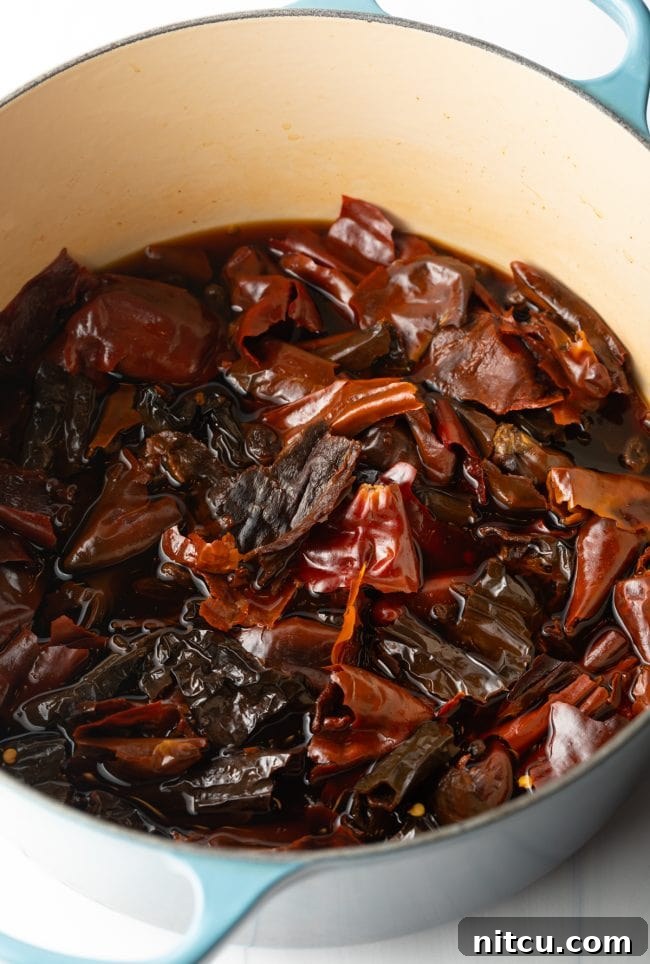 The Ultimate Carne Adovada Recipe 6 pot with steeped red chiles and raisins