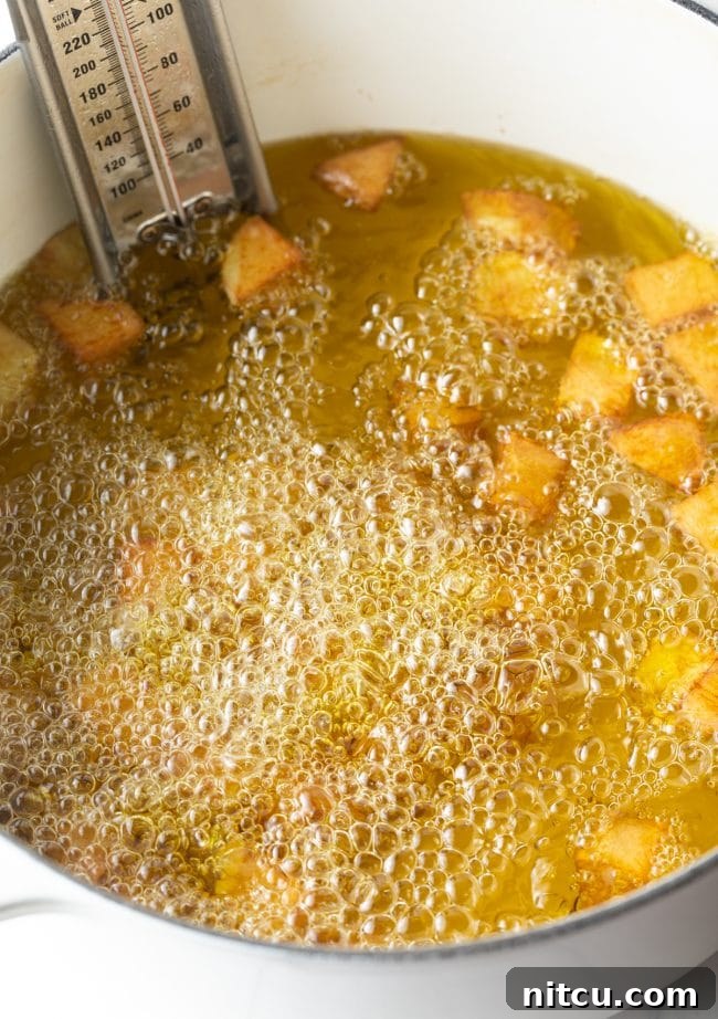 Fiesta Potatoes 8 Potatoes frying in hot oil in a large pot, with a thermometer clipped to the side