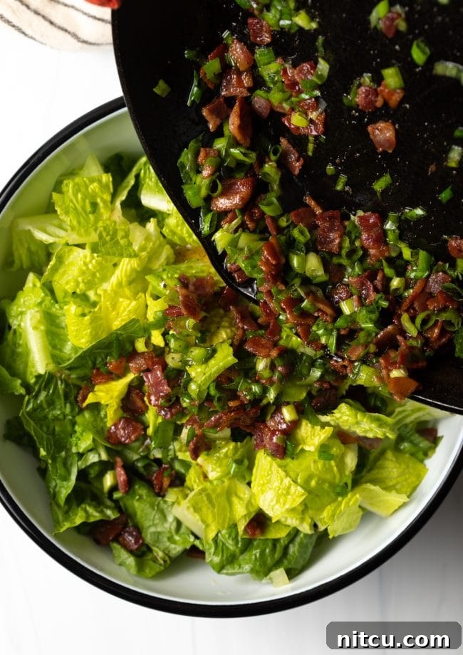 Sad Greens 8 pouring the hot bacon and grease with scallions into the bowl with chopped romaine