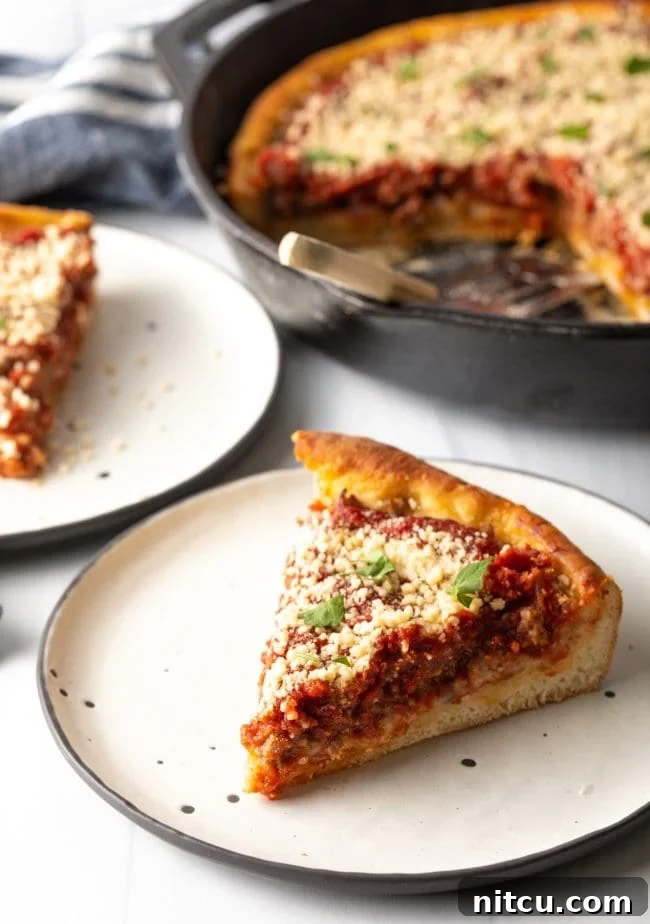 Iron-Clad Deep Dish Delight 2 A delectable slice of deep dish pizza on a plate, with the cast iron skillet visible in the background, showcasing its thick, golden crust and rich layers of cheese and sauce.