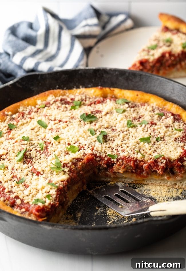 Iron-Clad Deep Dish Delight 3 A tempting side view of a freshly baked cast iron deep dish pizza, with a single slice removed revealing the generous layers of melted cheese, savory sausage, and robust tomato sauce within its thick, golden crust.