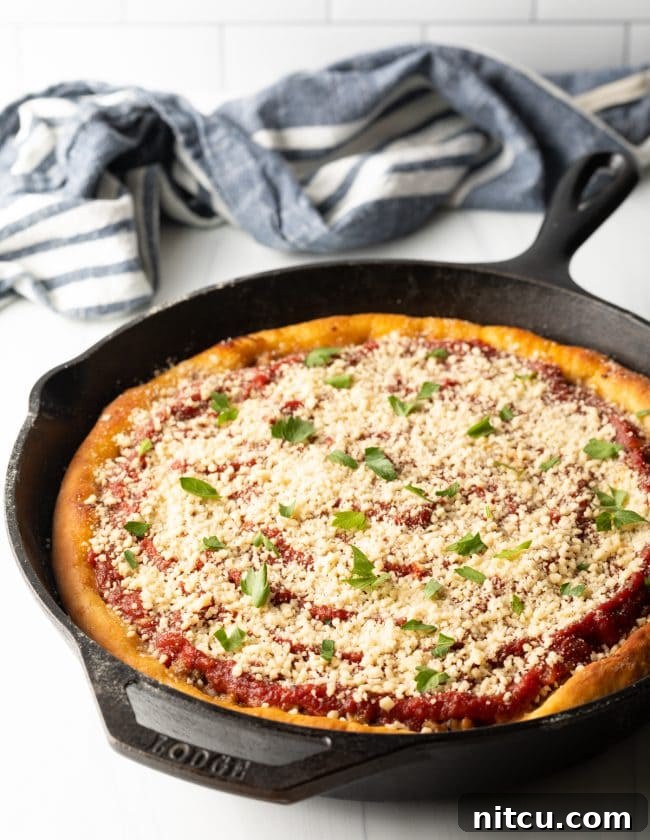 Iron-Clad Deep Dish Delight 9 A stunning side-top view of a baked Chicago-style deep dish pizza still nestled in its cast iron skillet, highlighting its impressive height and golden, crispy crust.
