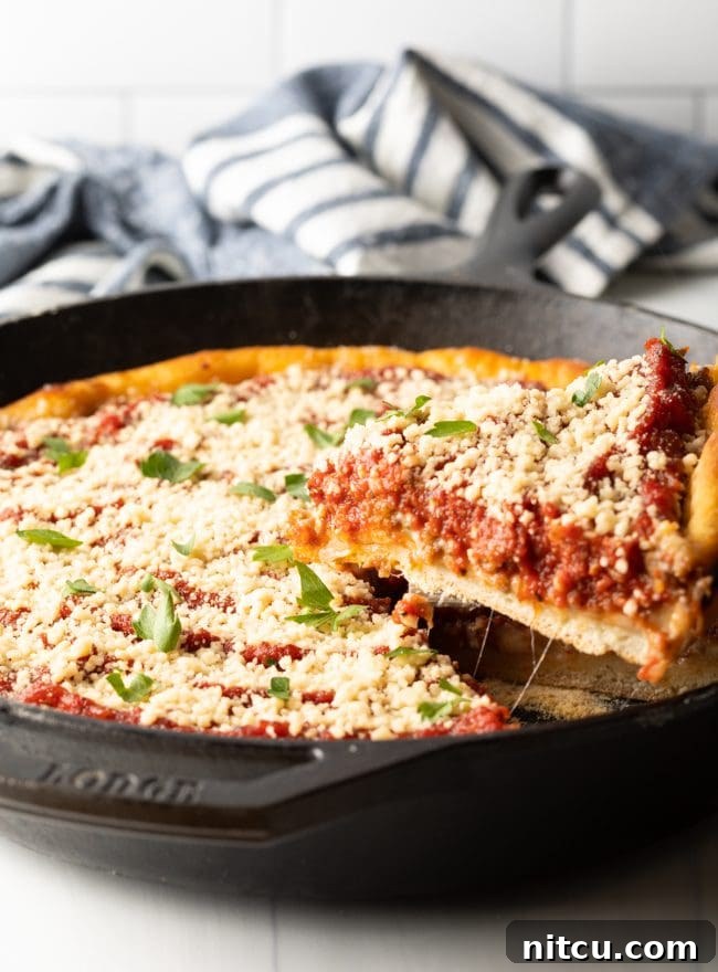 Iron-Clad Deep Dish Delight 10 A close-up shot of a perfect slice of deep dish pizza being carefully removed from a hot cast iron skillet, showcasing its thick crust and abundant, melted fillings.