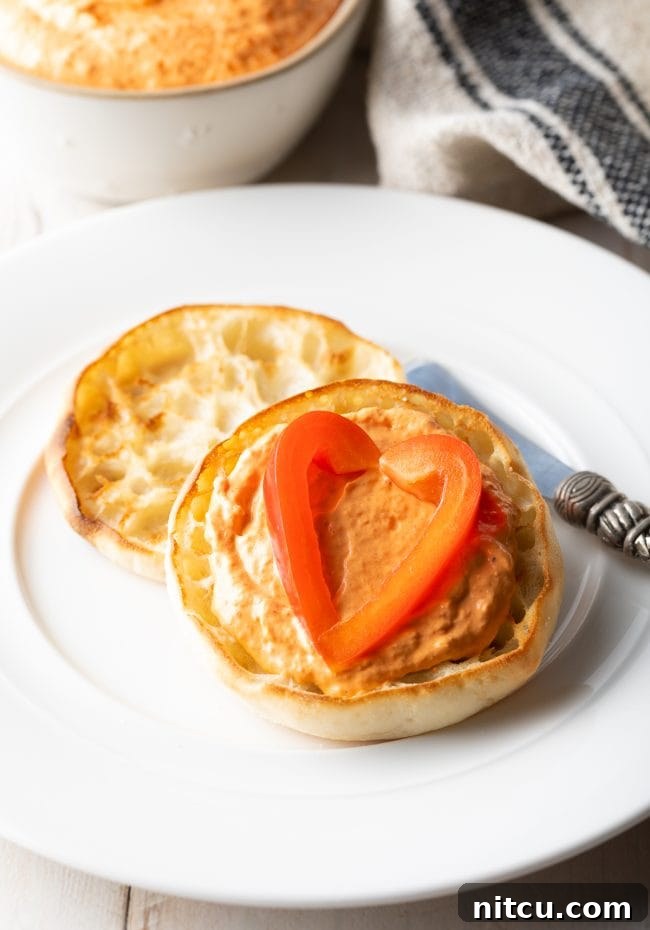 Roasted-Red-Pepper-Dip Roasted Red Pepper Dip served on an English muffin with sliced red pepper on top.
