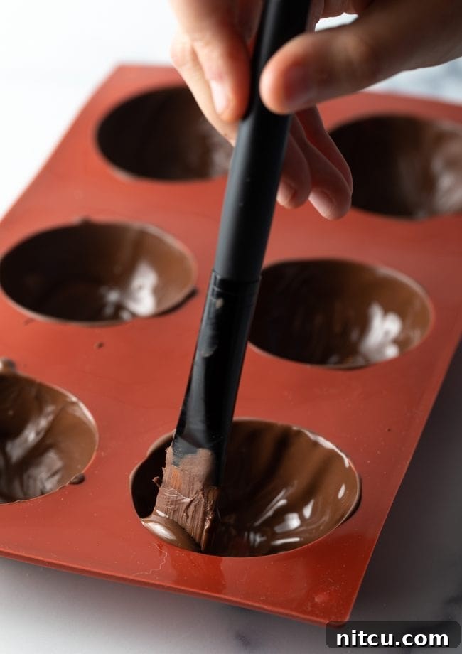 Magical Melting Cocoa 7 Spatula filling mold with melted chocolate.