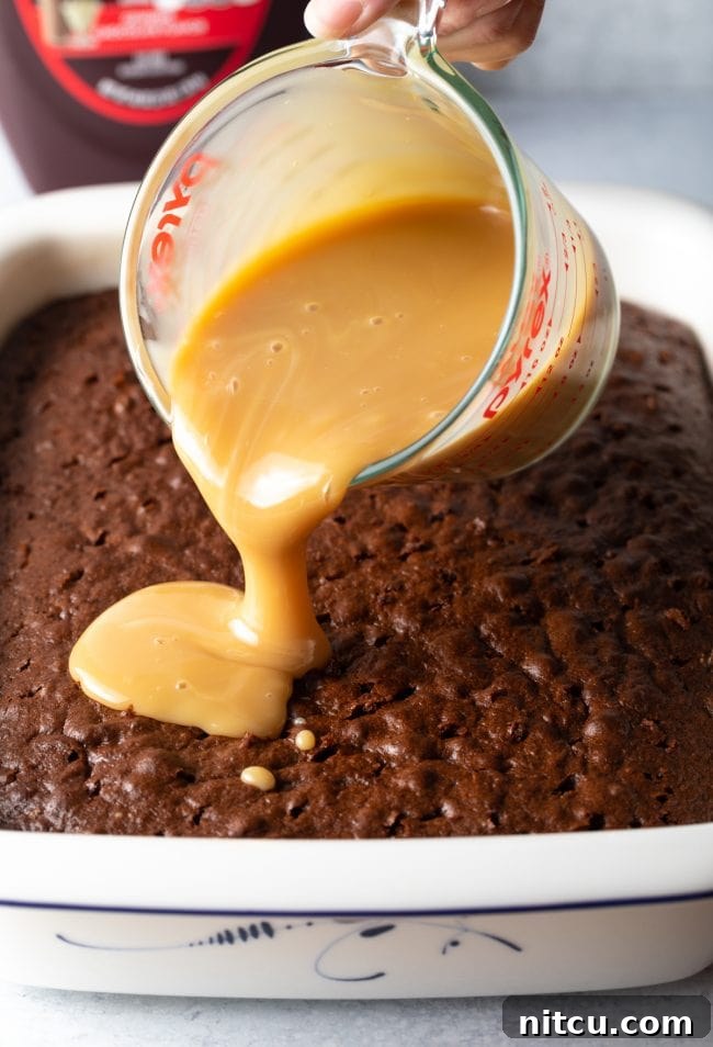 Sinfully Delicious Delight 7 A close-up of a freshly baked cake, dotted with numerous small holes, ready to absorb the luscious caramel and condensed milk mixture for an ultimate moist texture.