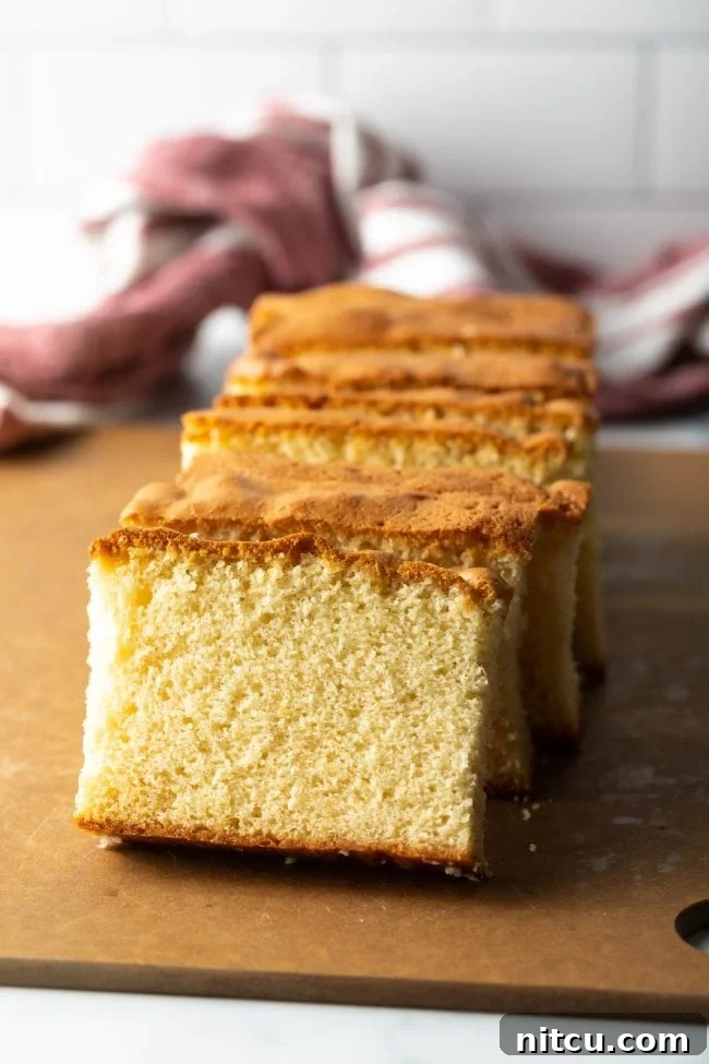 Featherlight Japanese Sponge Cake 13 slices of castella Japanese sponge cake stacked against each other resting on a brown cutting board