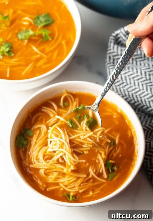 Mexican Fideo Noodle Bowl 13 top view of a spoon scooping a bite of flavorful Mexican soup with fideo noodles