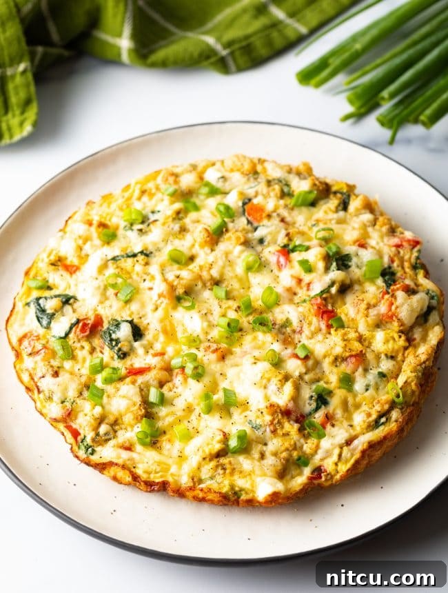 Egg white frittata on a serving platter garnished with chopped scallions