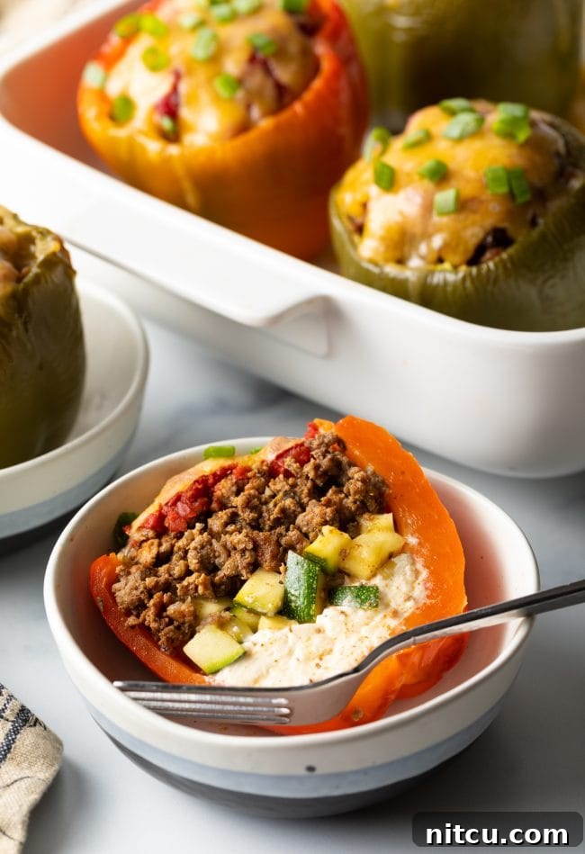 Savory No Rice Keto Beef Stuffed Peppers 13 Mediterranean stuffed bell pepper without rice cut in half in a bowl with fork.