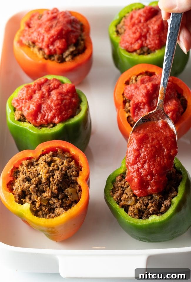 Savory No Rice Keto Beef Stuffed Peppers 8 Adding crushed tomato sauce to the ground beef stuffed in raw bell peppers.