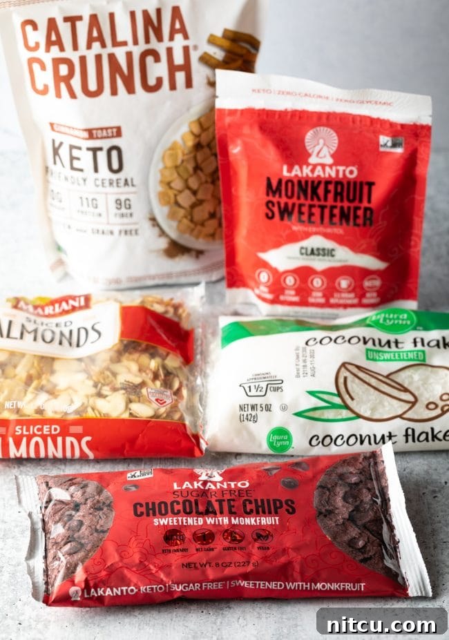 Recipe ingredients laid out in packages: Keto chocolate chips, unsweetened coconut, sliced almonds, and monk fruit sweetener.