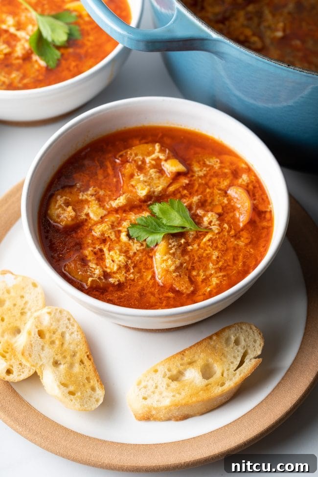 Rustic Spanish Garlic Soup 13 two bowls of sopa de ajo spanish soup on plates with toasted baugette slices