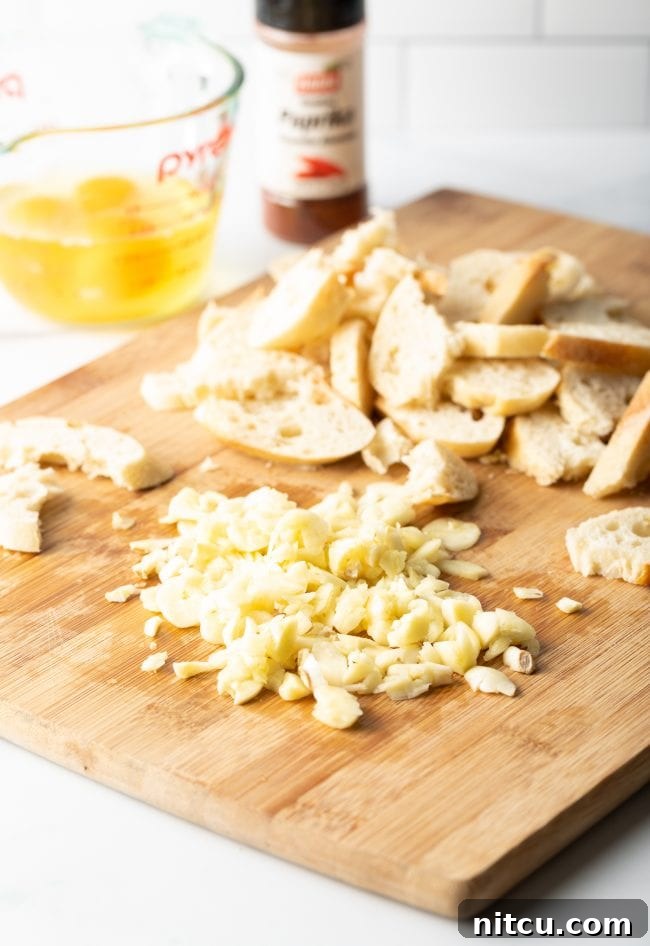 Rustic Spanish Garlic Soup 5 Sopa De Ajo - chopped garlic and baguette slices on a wood cutting board